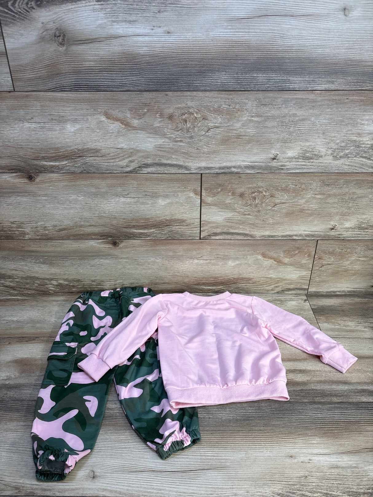 Pink long sleeve top and green pink camo pants kids outfit set on wood floor
