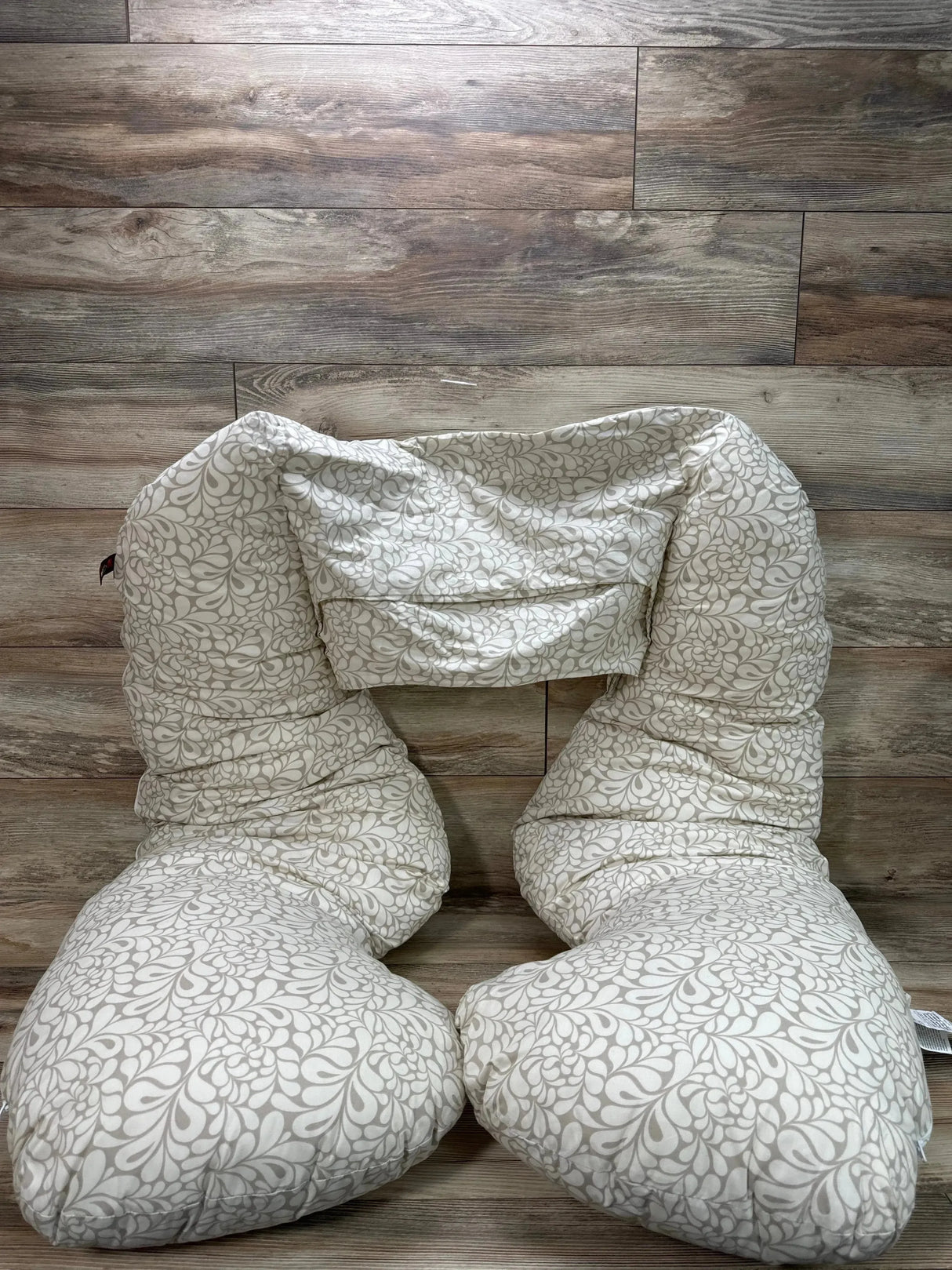 Front view of Leachco Back 'N Belly maternity pillow showing U-shaped support and taupe Splash cover on wood floor