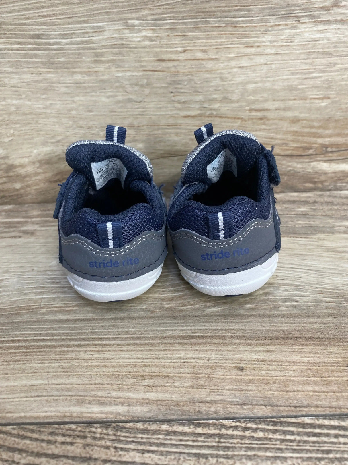 Side view of navy Stride Rite Soft Motion Kylo toddler sneaker showcasing hook-and-loop strap and cushioned sole on white background