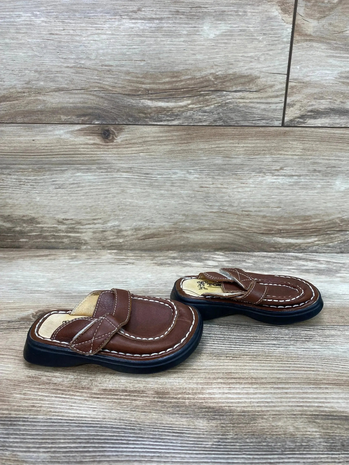 Three-quarter view of Tom Dog leather toddler clogs size 5/6C showing slip-on design and stitching on white background