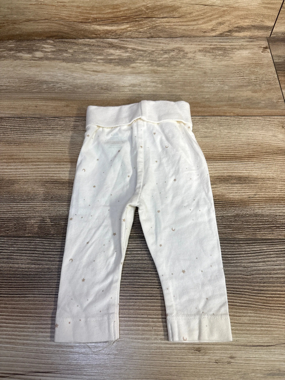 Front view of H&M newborn pants showcasing foldover waistband and cuffed hems on a wood floor
