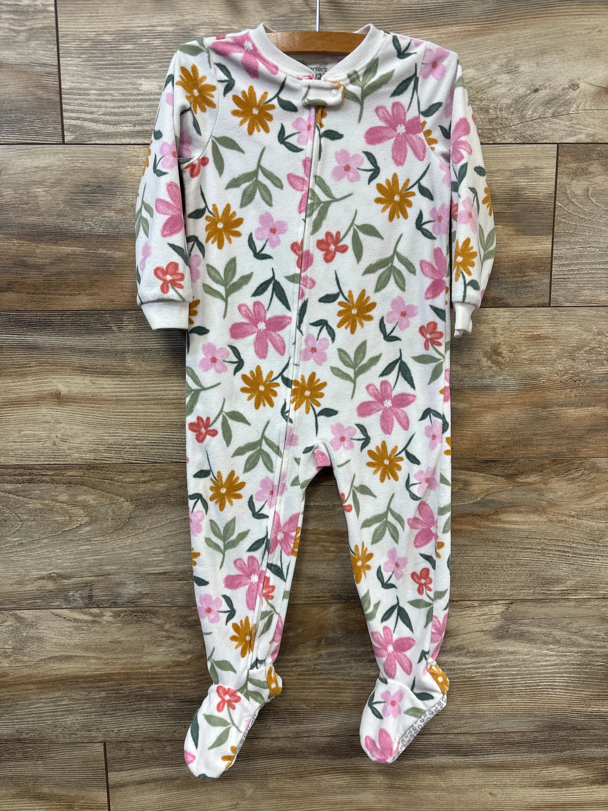Front view of Carter’s white 3T blanket sleeper showcasing floral print, footed legs, and front zipper on wood background