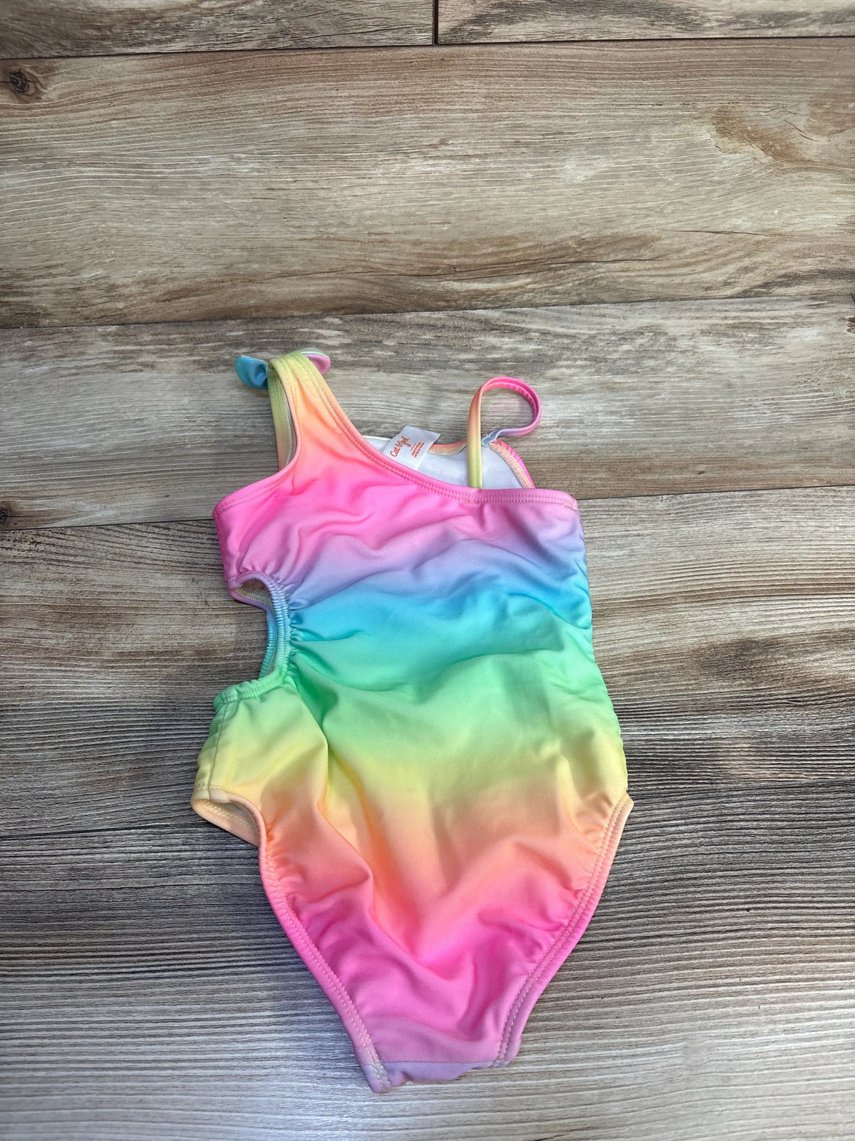 Cat & Jack toddler one-piece rainbow gradient cut-out swimsuit on a wooden floor
