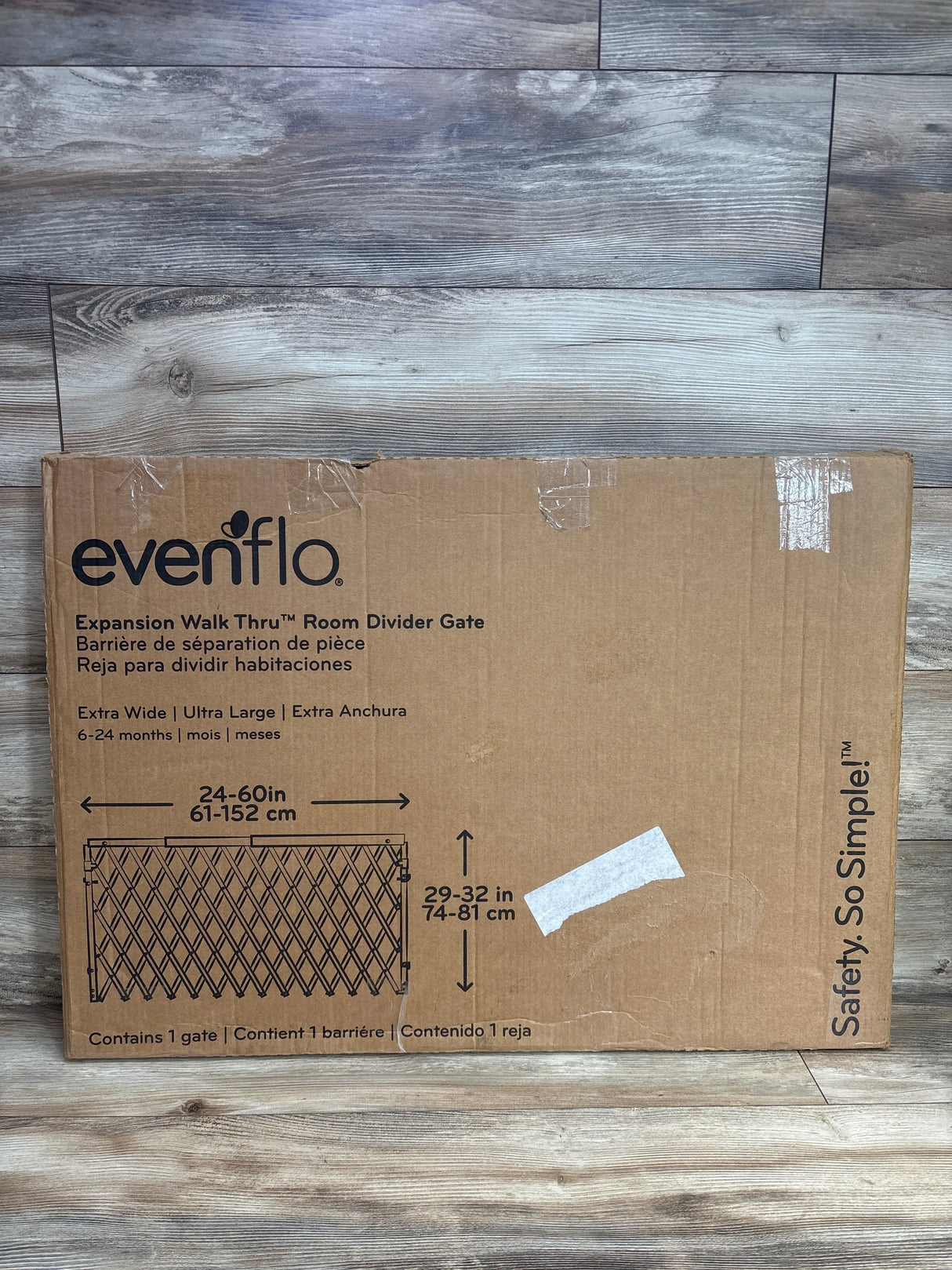 Evenflo Expansion Walk Thru room divider gate box on wood floor, baby safety gate packaging