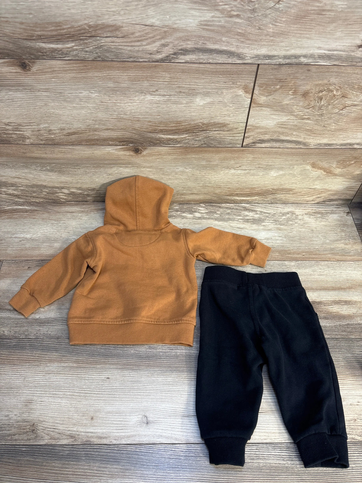 Toddler brown hoodie and black jogger pants set on wood background