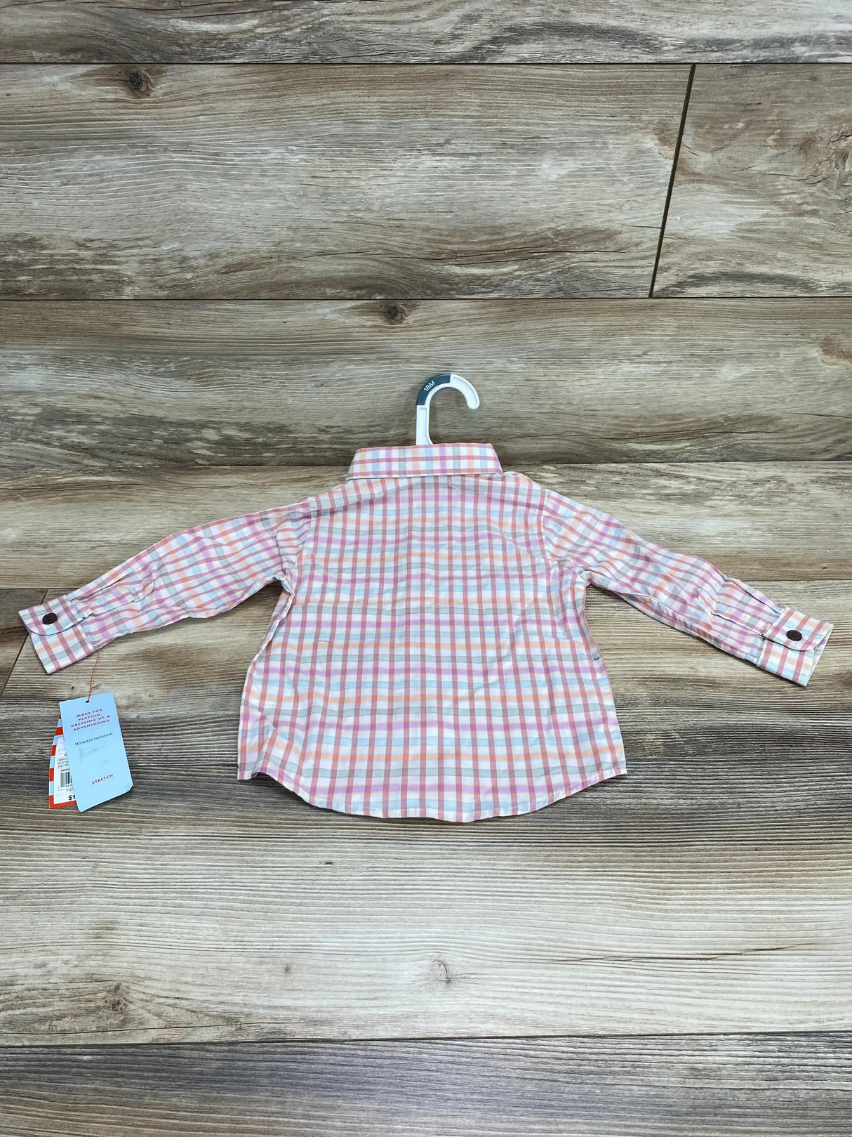 Back view of NWT Cat and Jack plaid button-up shirt sz 18m showcasing pink and white check pattern with hangtag hanging on wood plank floor