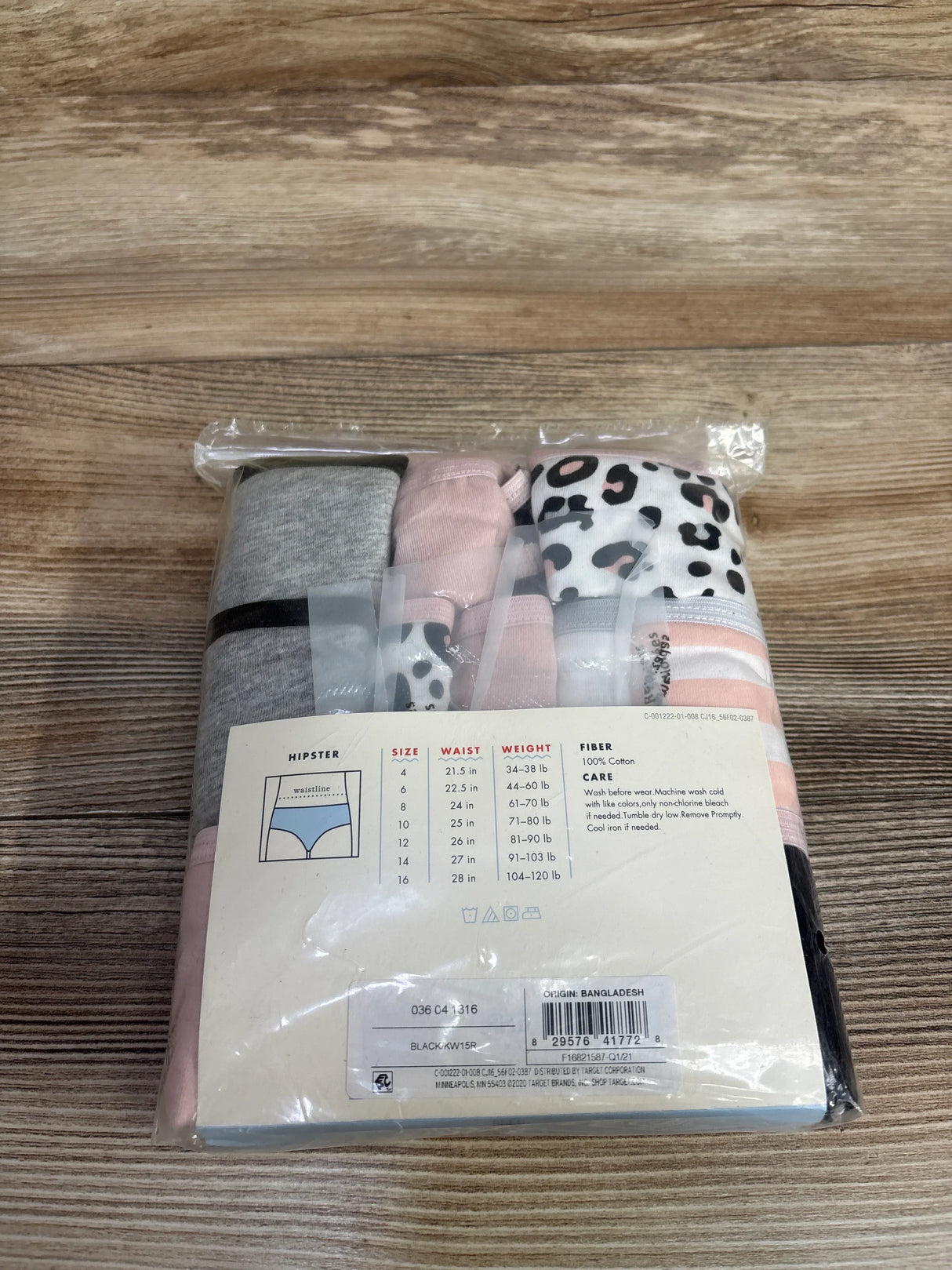 Pack of women's hipster underwear in grey, pink, and leopard print on wood surface