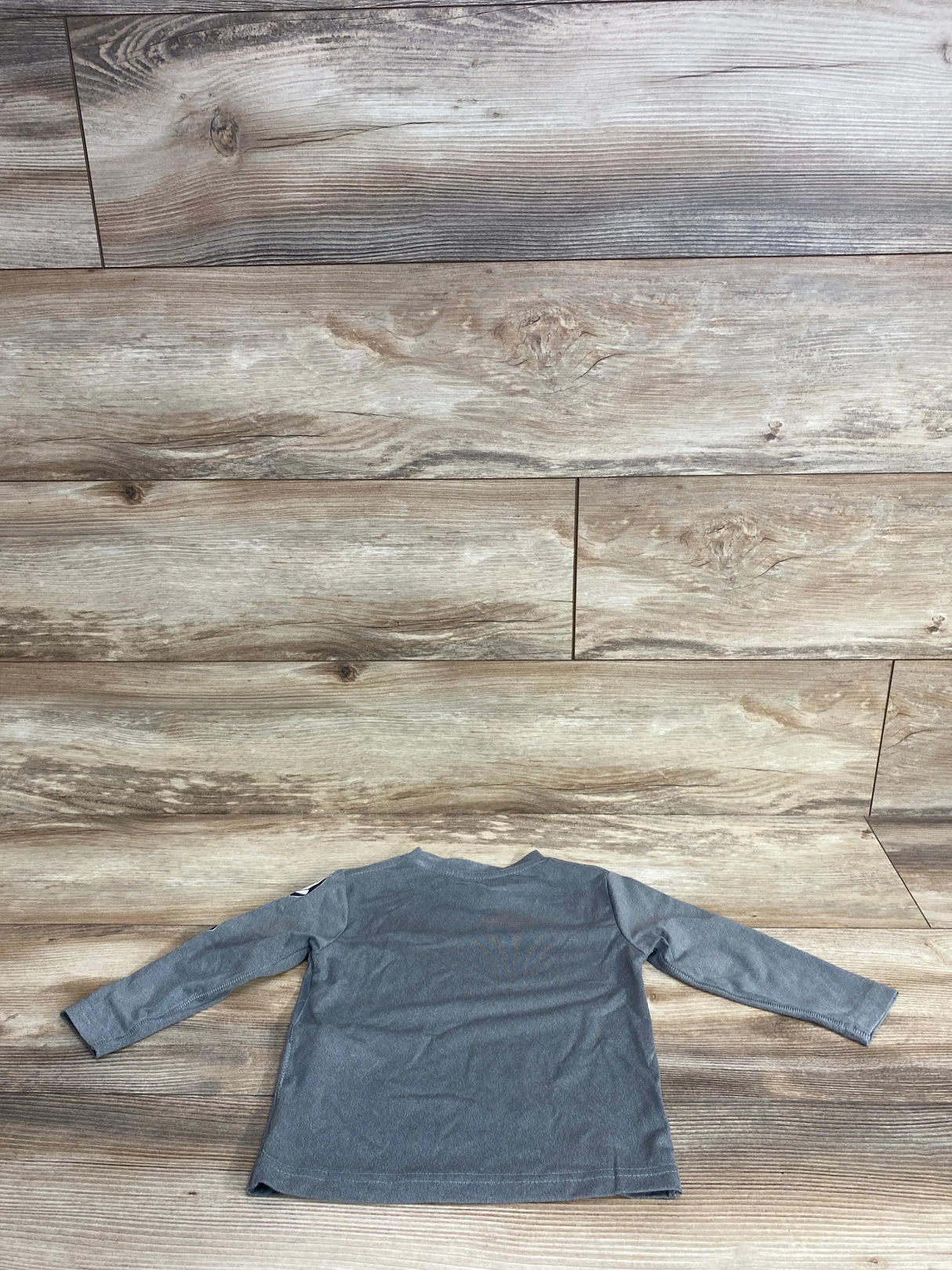 Back view of Volcom toddler gray long-sleeve shirt size 2T showing plain back and small sleeve logo on wooden floor background