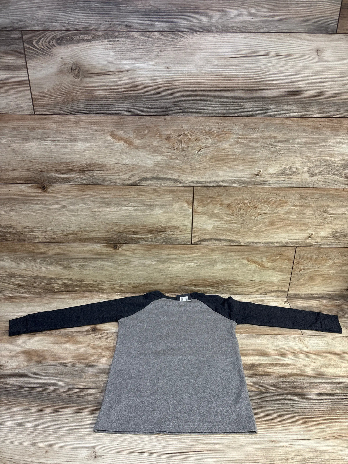 Flat-lay of toddler long-sleeve shirt showing heather gray body and dark raglan sleeves, size 4T, on wood background