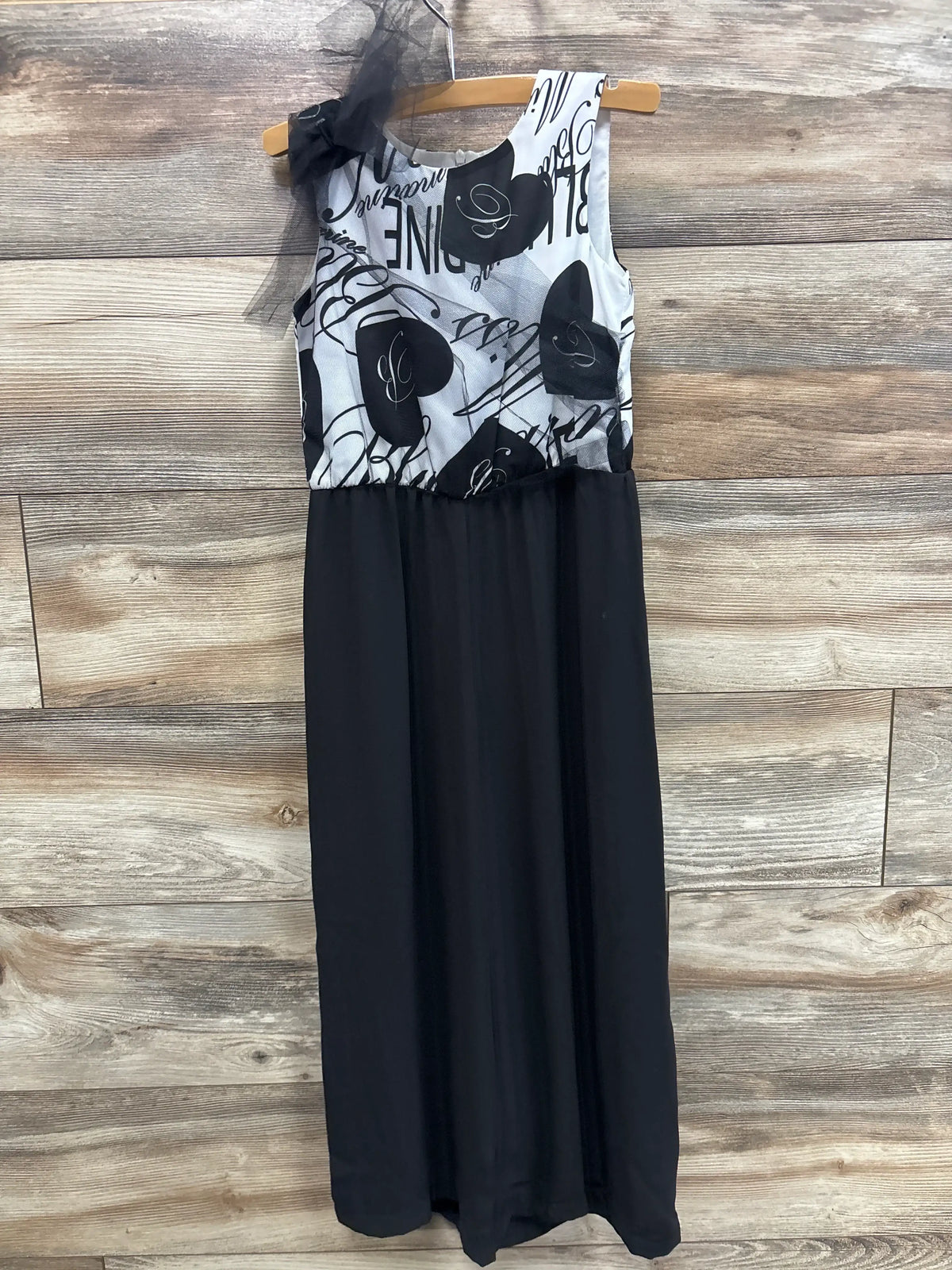 Front view of Miss Bluemarine white tulle sleeveless jumpsuit with patterned bodice and black lower section on wood hanger