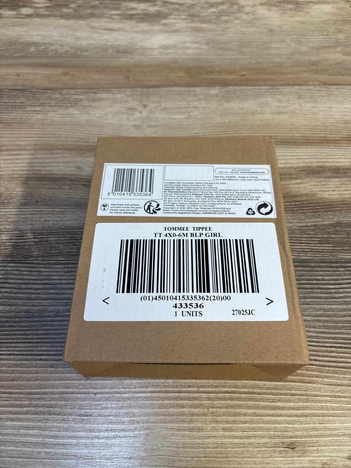 Top view of Tommee Tippee 4-pack breast-like soothers box showcasing barcode and shipping labels on a wood surface
