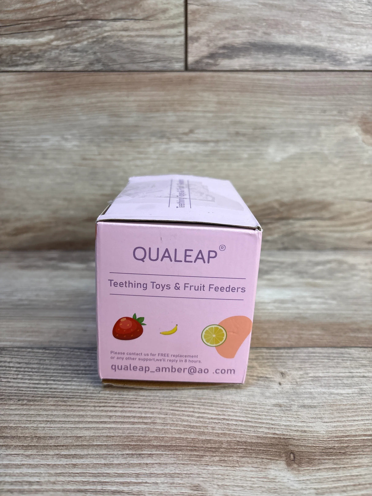 Qualeap teething toys and fruit feeders packaging photographed on a wooden surface