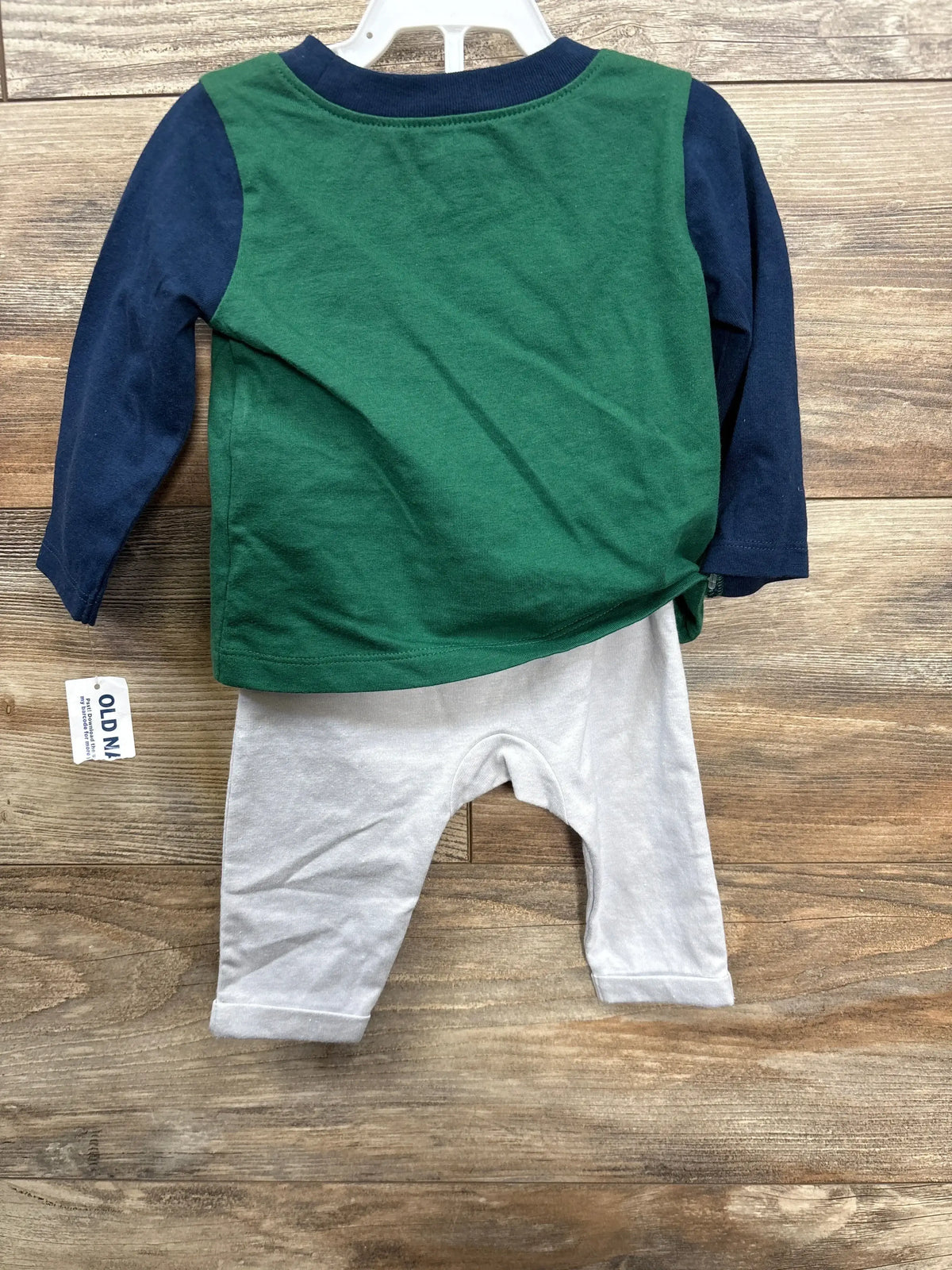 Back view of Old Navy raglan shirt and pants set, size 3-6m, green and navy top with light gray pants on wood background
