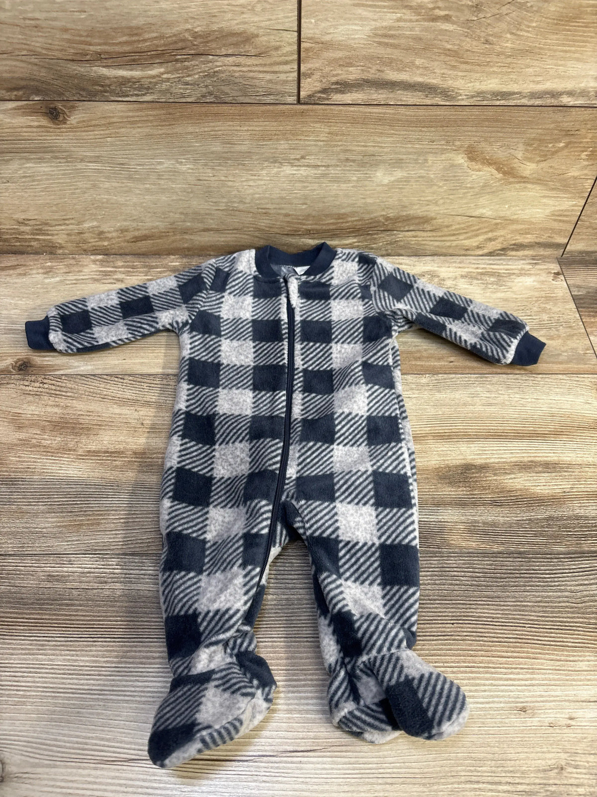 Front view of PL Baby plaid blanket sleeper showcasing grey plaid pattern and full-length zipper on wood flooring