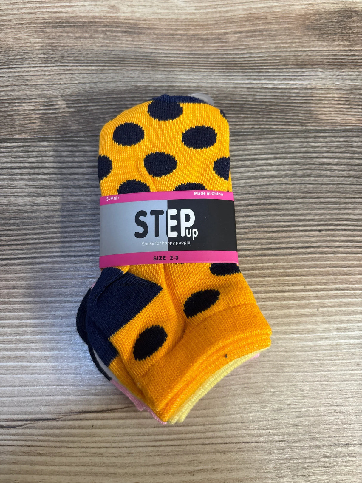 Yellow and navy polka dot toddler socks, size 2-3, on wood background