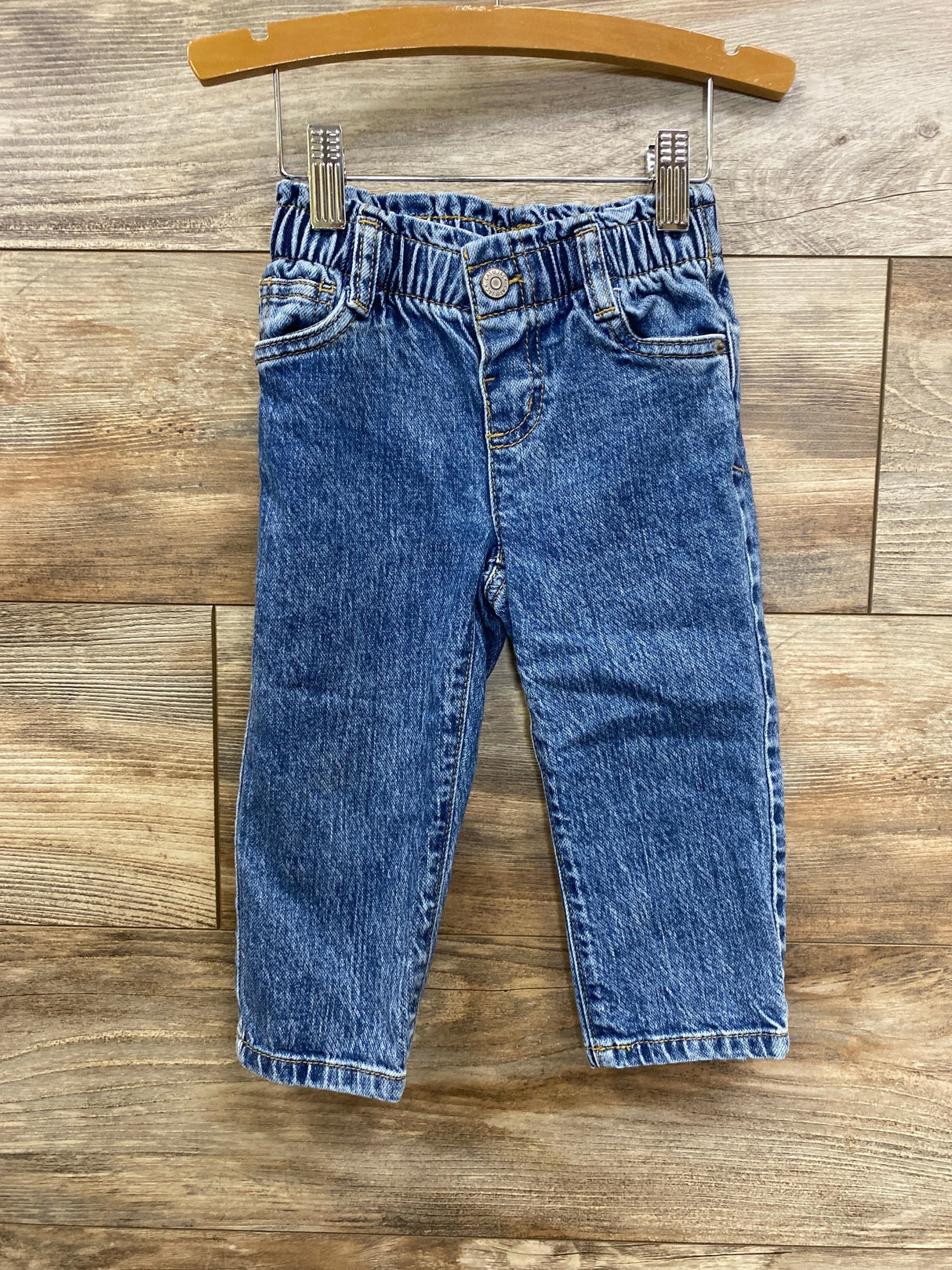 Blue denim toddler jeans with elastic waistband on wooden hanger, kids clothing resale