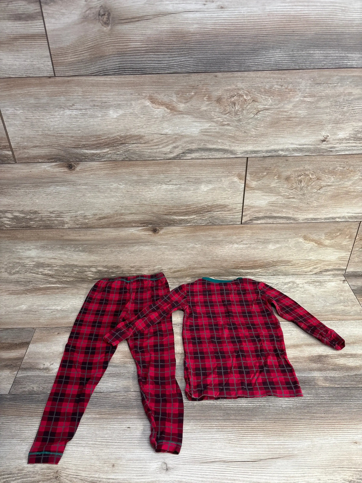 Red and black plaid kids pajama set on wooden floor