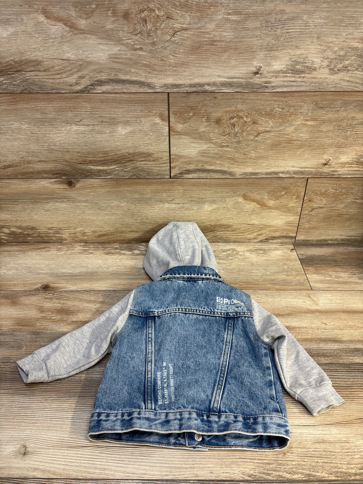 Kids denim jacket with gray hoodie, resale children's clothing on wood floor