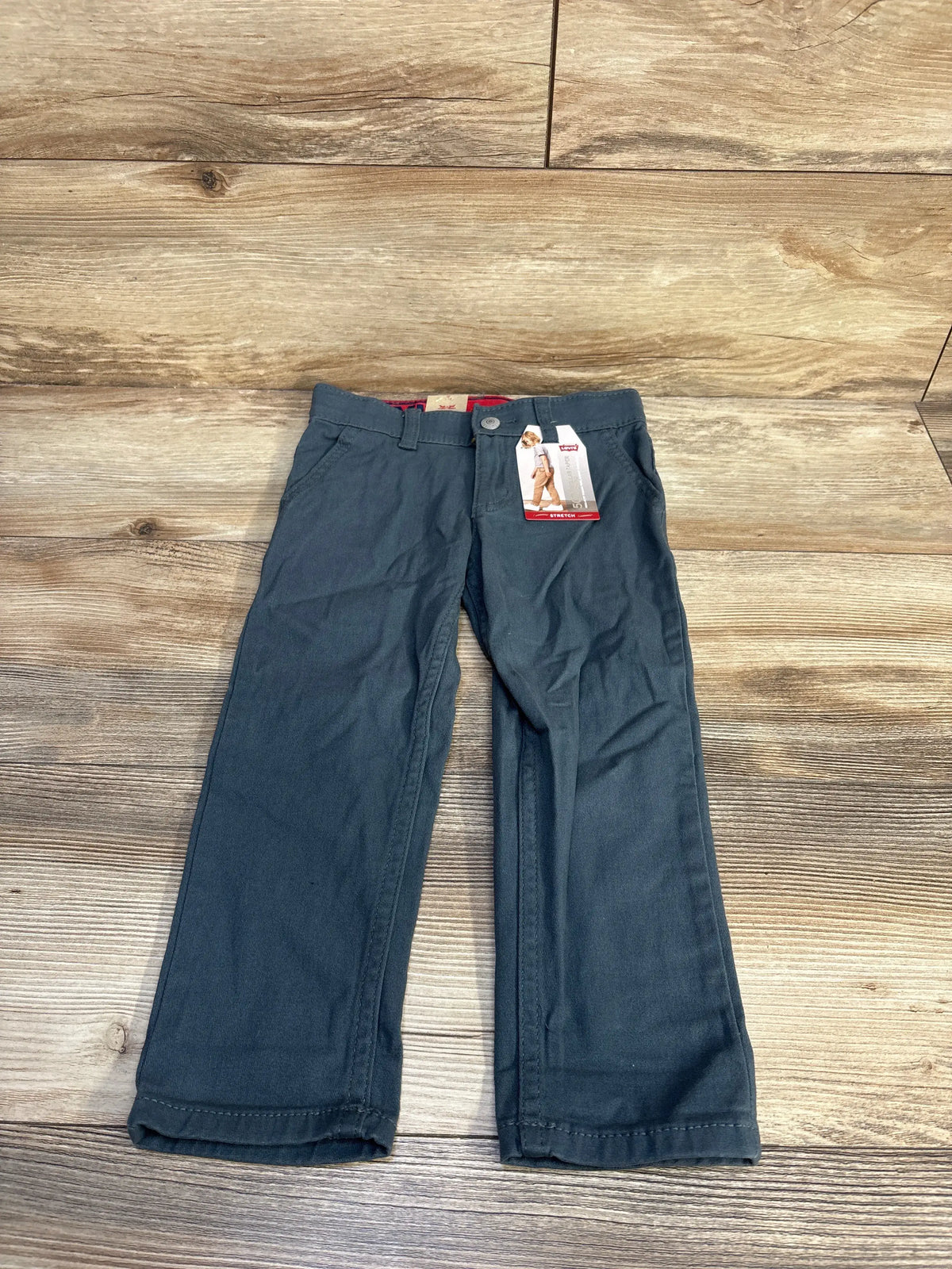 Front view of NEW Levi’s 502 Regular Taper chino pants in grey showcasing tapered legs and adjustable waistband on a wooden floor