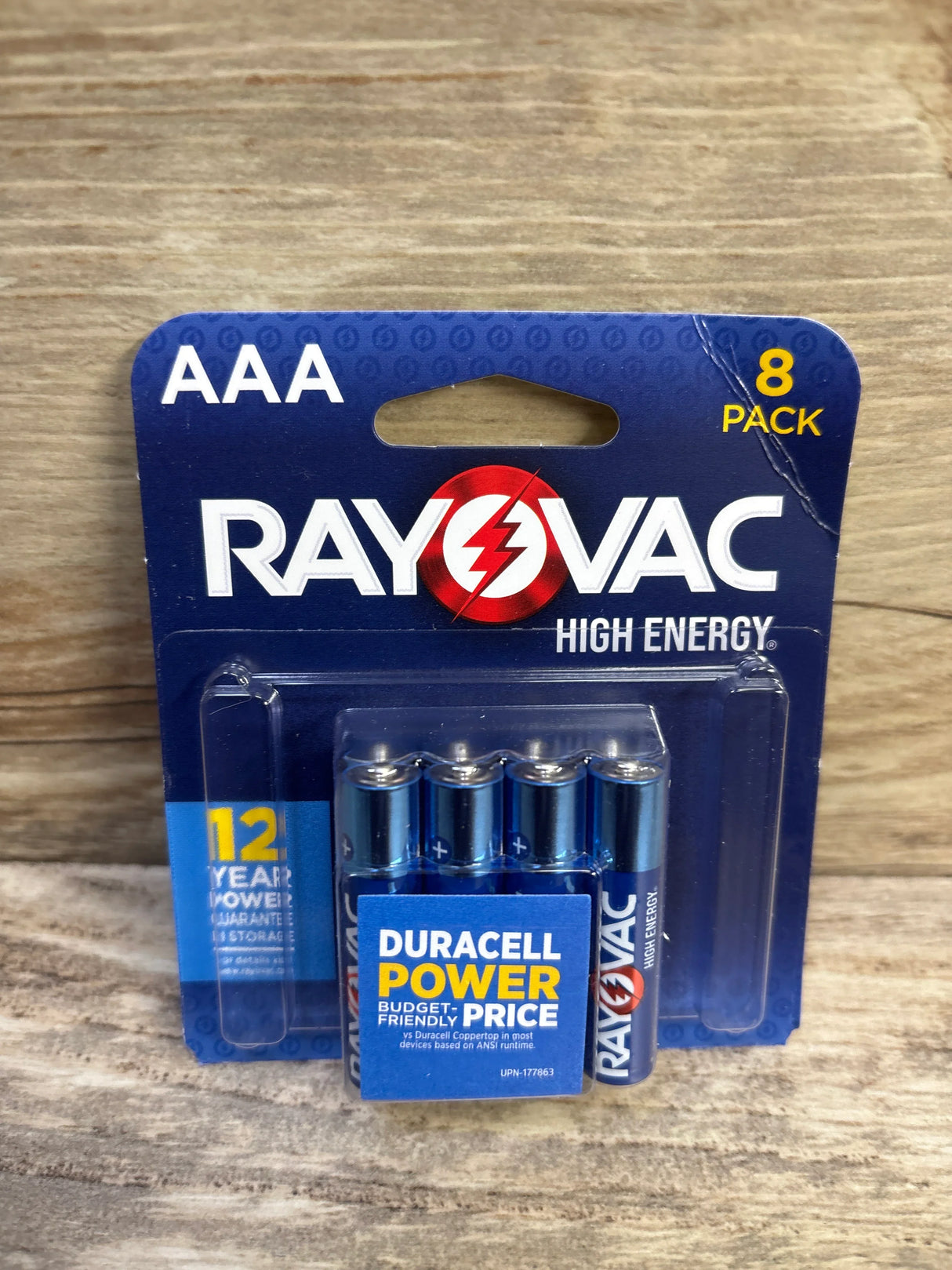 Front view of Rayovac High Energy AAA alkaline 8-pack showing batteries in clear blister pack on wood background