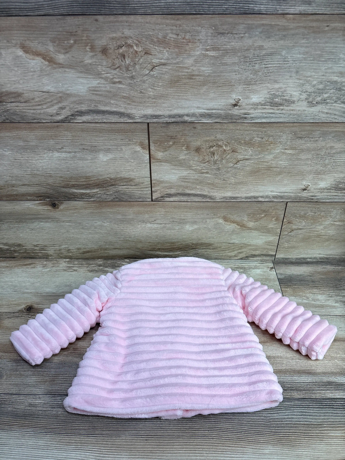 Little Me pink faux fur ribbed coat for infants, size 18 months, on a wooden background