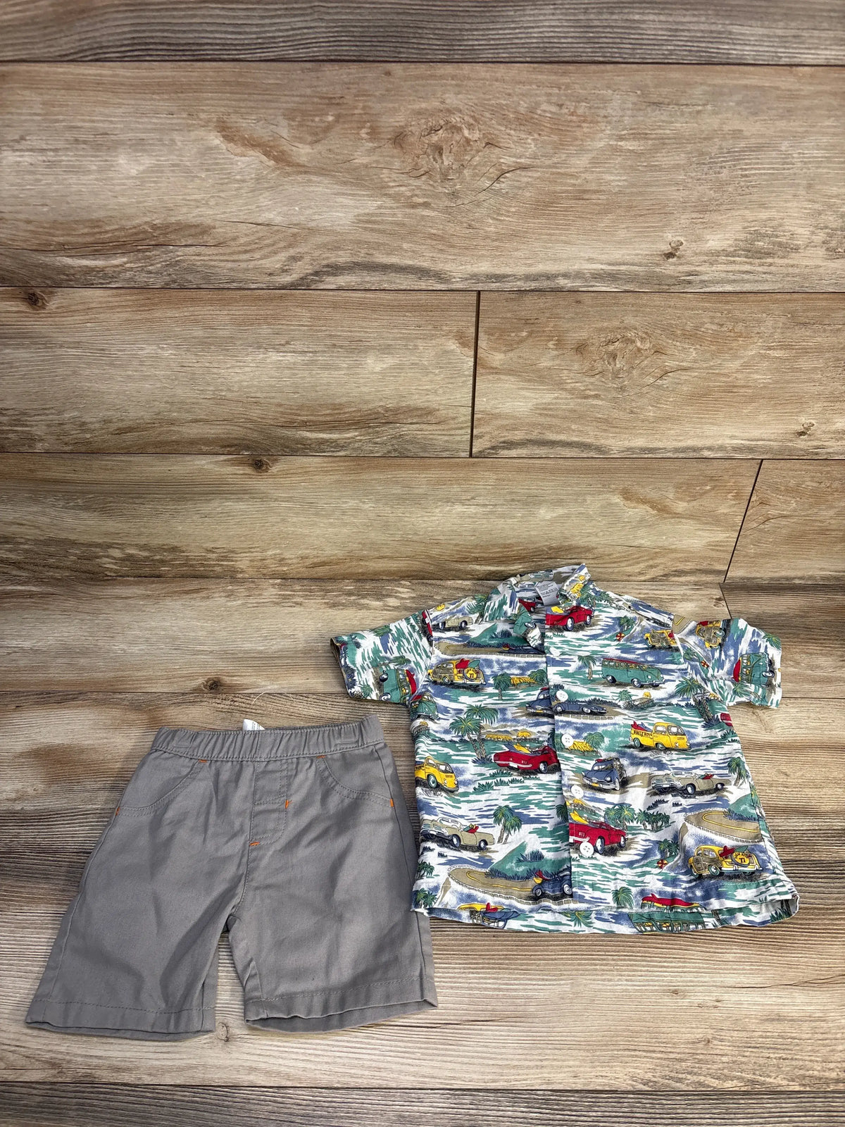 Top-down view of white Bugle Boy 2-piece button-up shirt and shorts set on a wood-grain background