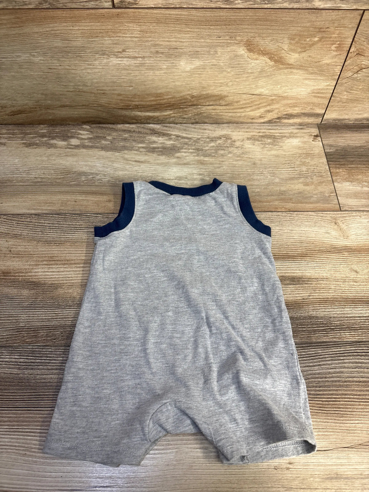 Front view of Chick Pea Safari Pals shortie romper in grey, size 3-6 months, showcasing navy trim on a wood floor