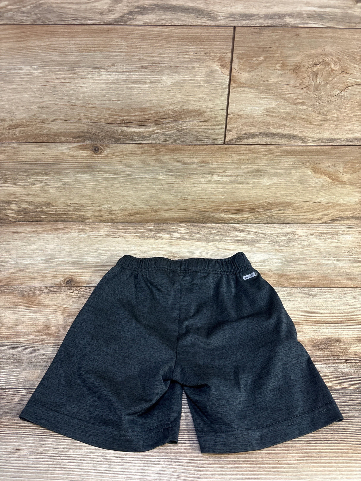 Front view of Old Navy Go-Dry toddler shorts showcasing elastic waistband and moisture-wicking fabric on wood floor