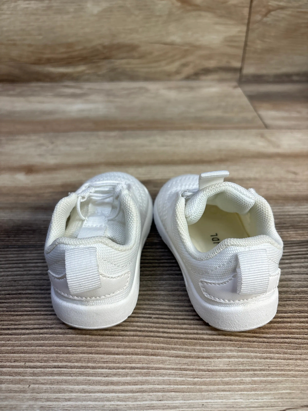 Rear view of white Morendl slip-on mesh sneakers showcasing pull tabs and padded collars on a wood surface