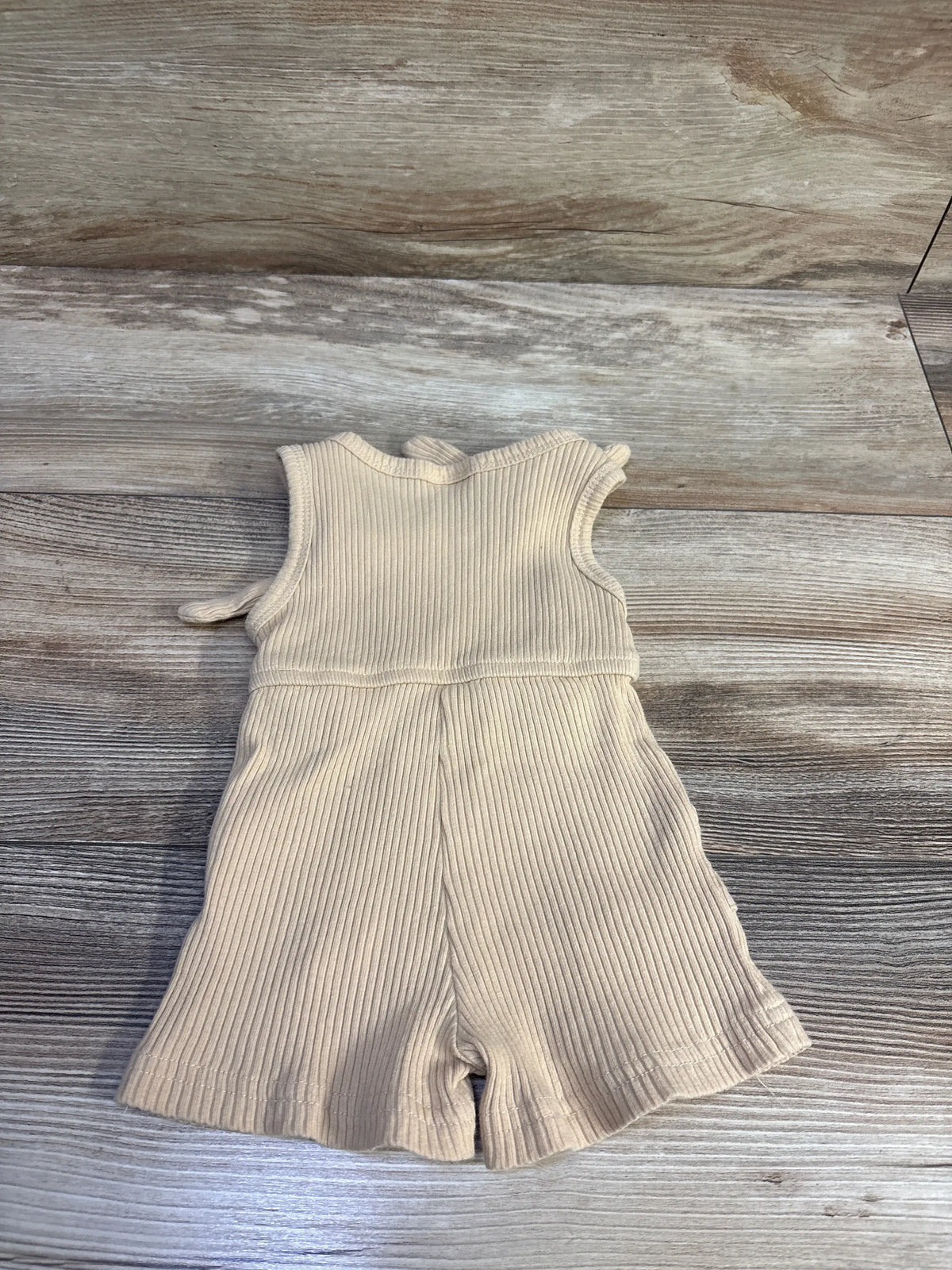 Beige ribbed baby romper by Me n Mommy To Be on a wooden background.