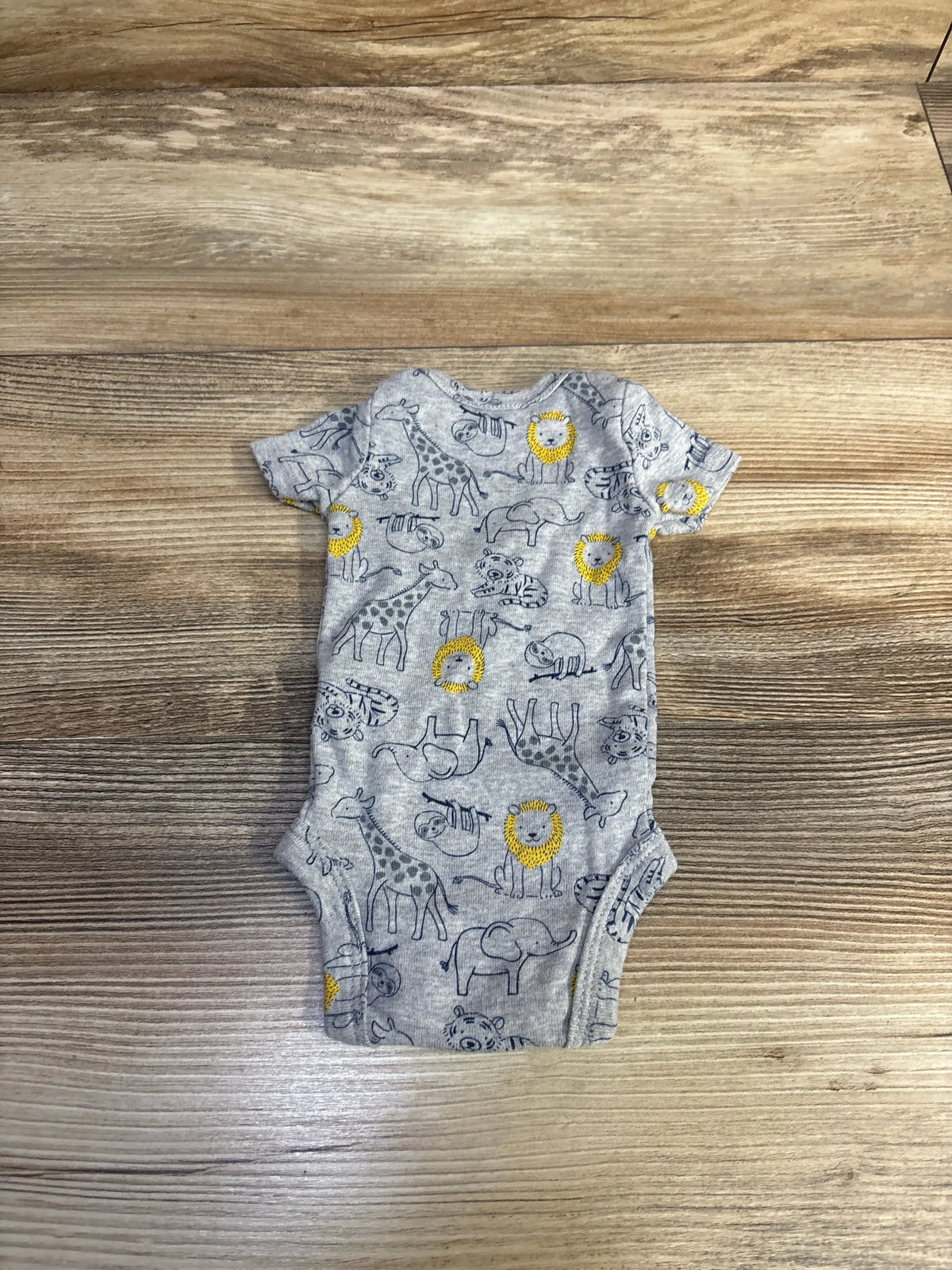 Front view of Child of Mine bodysuit showcasing gray zoo animal print and short sleeves on a wood floor