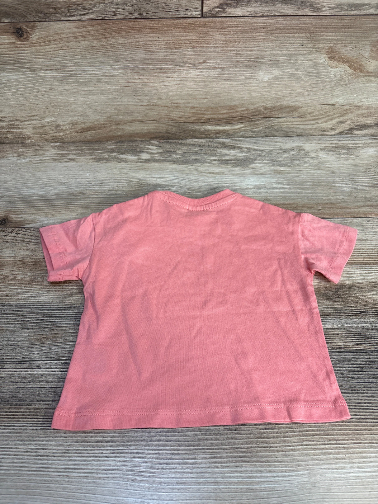 Pink short sleeve toddler t-shirt back view on wood background