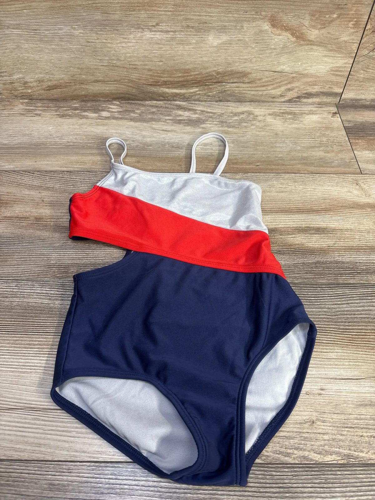 Front view of Red White Blue 1pc Cut-Out Swimsuit with colorblock white red and navy panels and side cut-out sz 5T on wood plank floor