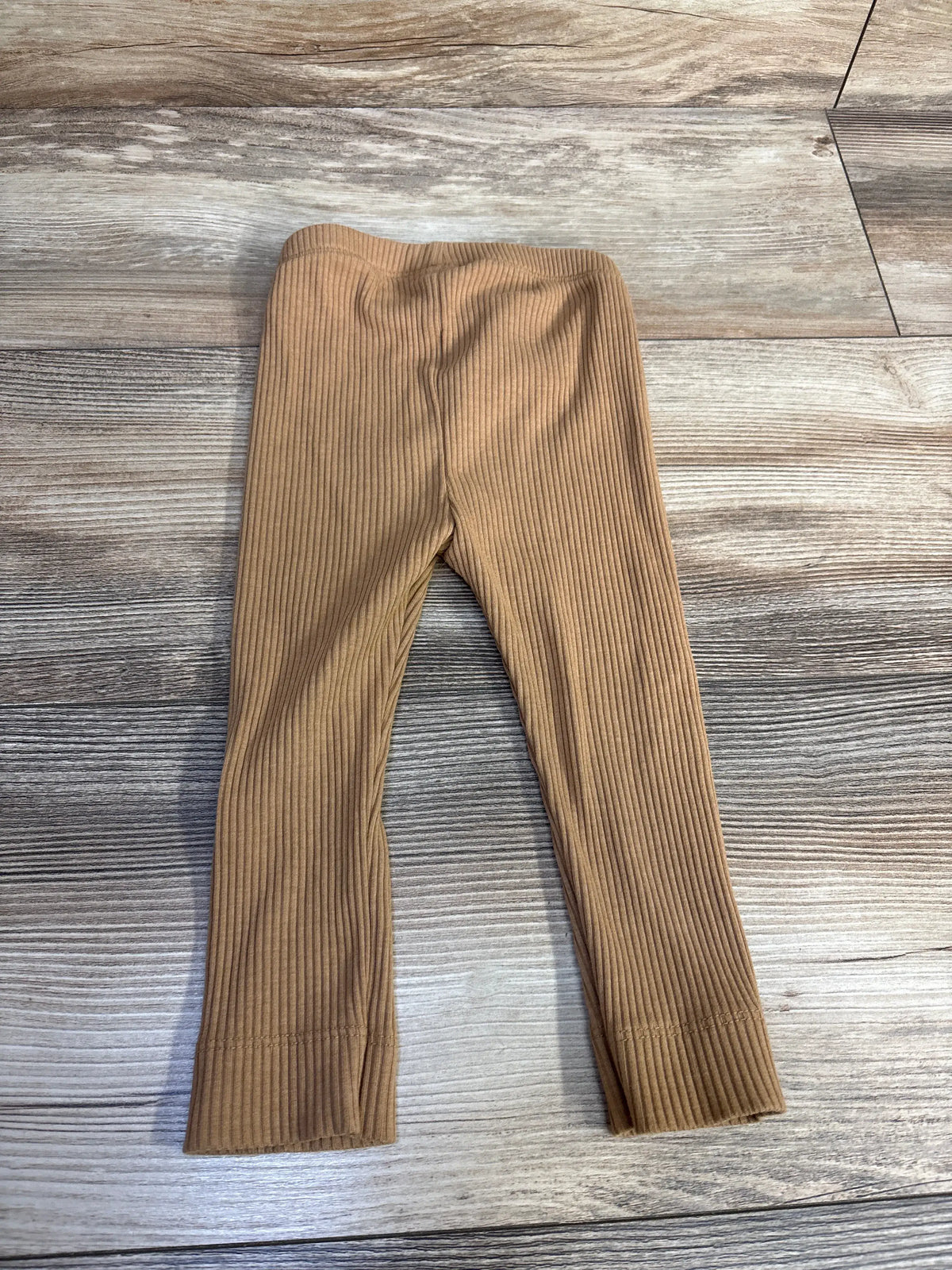 Front view of Old Navy brown ribbed leggings showcasing full-length legs and elastic waistband with a wood-look background