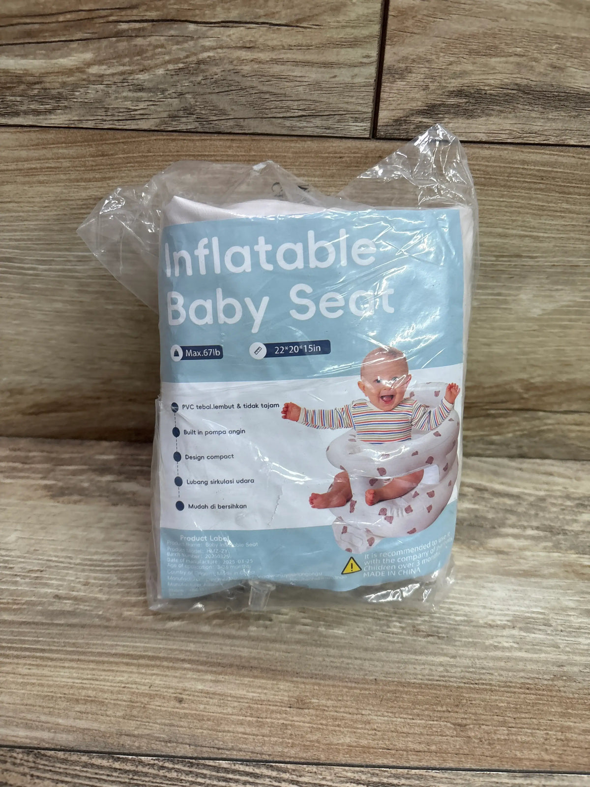 Front view of inflatable baby seat package showcasing 22 by 20 by 15 inch dimensions and baby illustration on wood-patterned floor