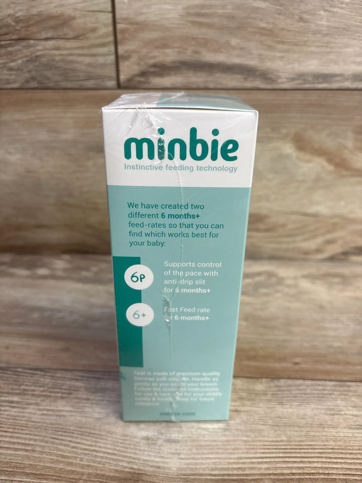 Front view of Minbie 6m+ Feeding Kit box showing logo and text about two 6m+ feed rates (6P and 6+) on wooden surface