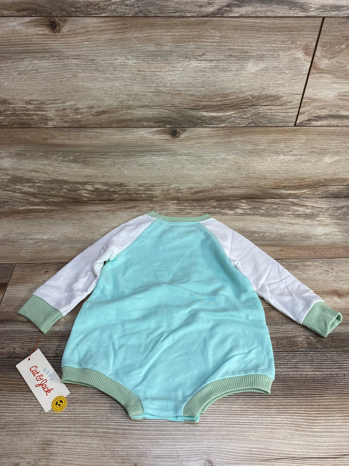 Mint green and white baby romper with ribbed cuffs, laid on wooden floor, Cat & Jack tag attached