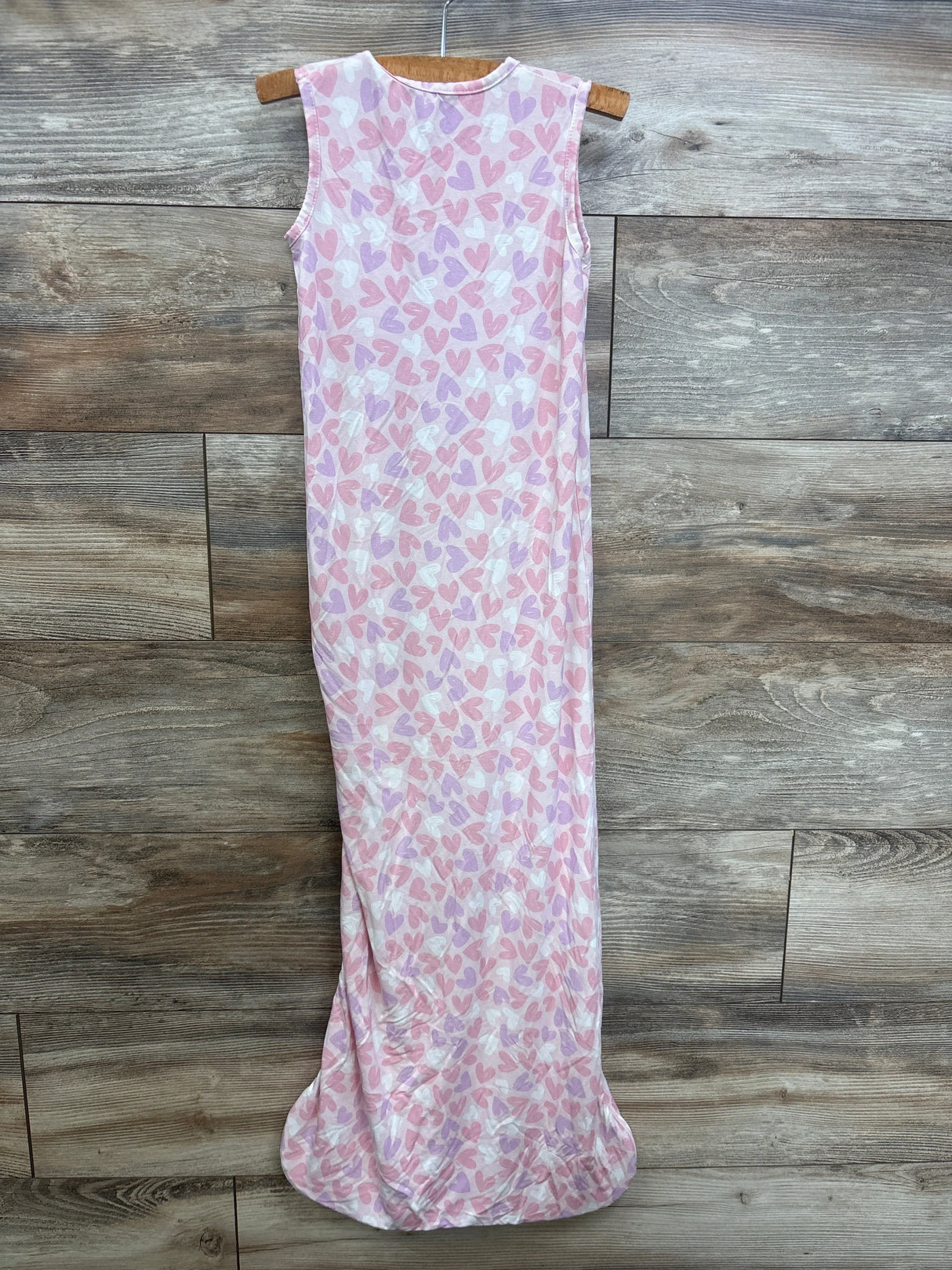 Infant pink heart print sleeveless sleep sack gown on wooden hanger, wood background