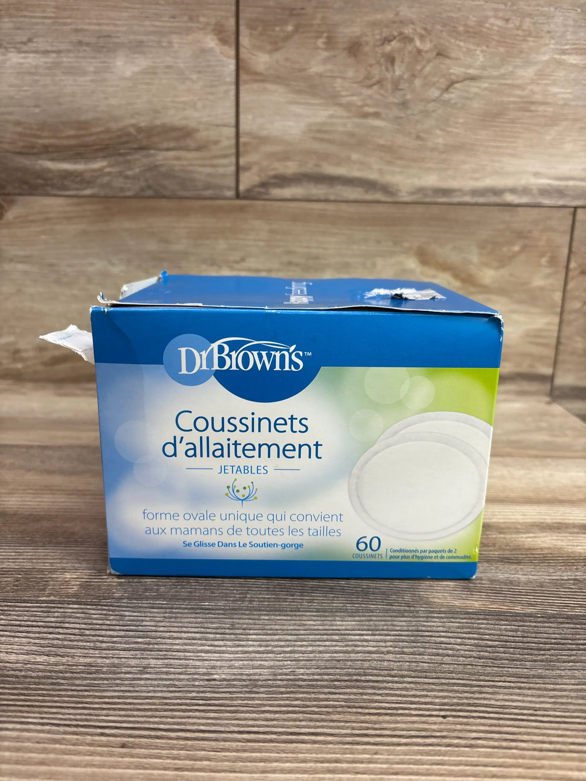 Box of Me n Mommy To Be disposable breast pads, 60 count, on a wooden surface.