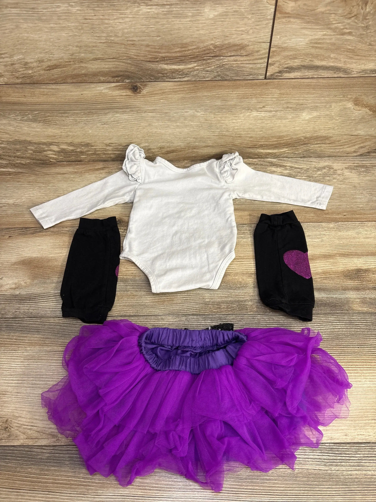 White ruffle onesie with black heart leggings and purple tutu skirt for baby girl
