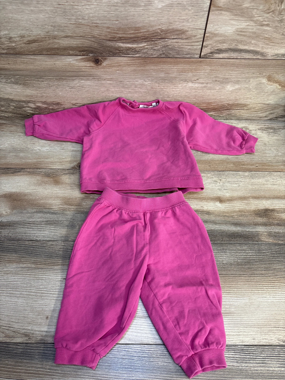 Pink toddler sweatshirt and jogger pants set on wooden floor