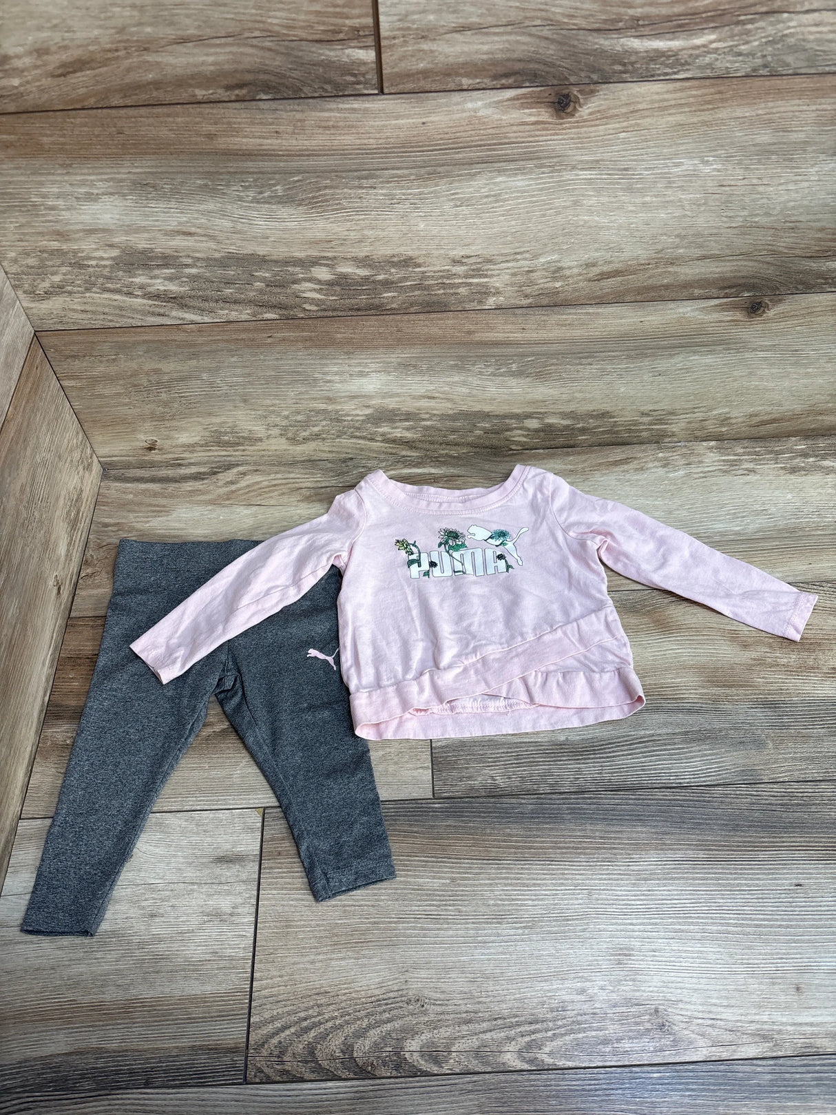 Toddler girl outfit with pink unicorn top and gray leggings on wood floor