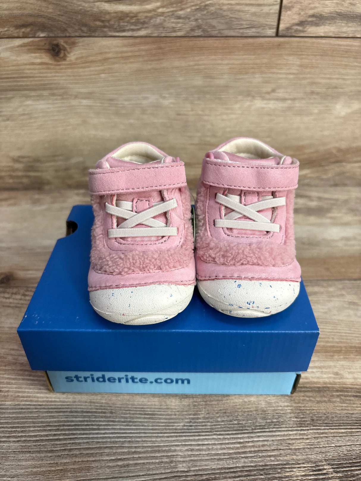 Front view of pink Stride Rite toddler Cedar sneakers size 4C showing velcro strap, faux laces and sherpa trim on blue box