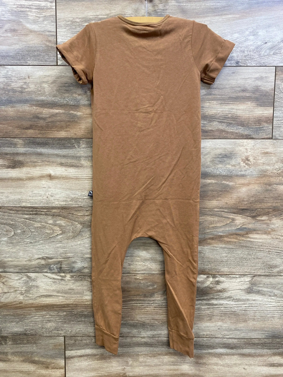 Front view of Rags Romper Browns sz 5/6 showcasing brown short sleeves and elastic neckline with a wood-look background