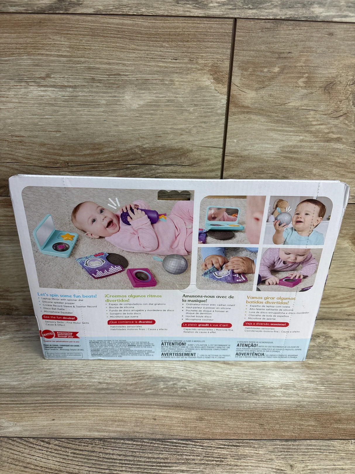 Rear of Fisher-Price Mini Me Moments DJ Gift Set box showing toy microphone, play records, and photos of babies on a wood floor