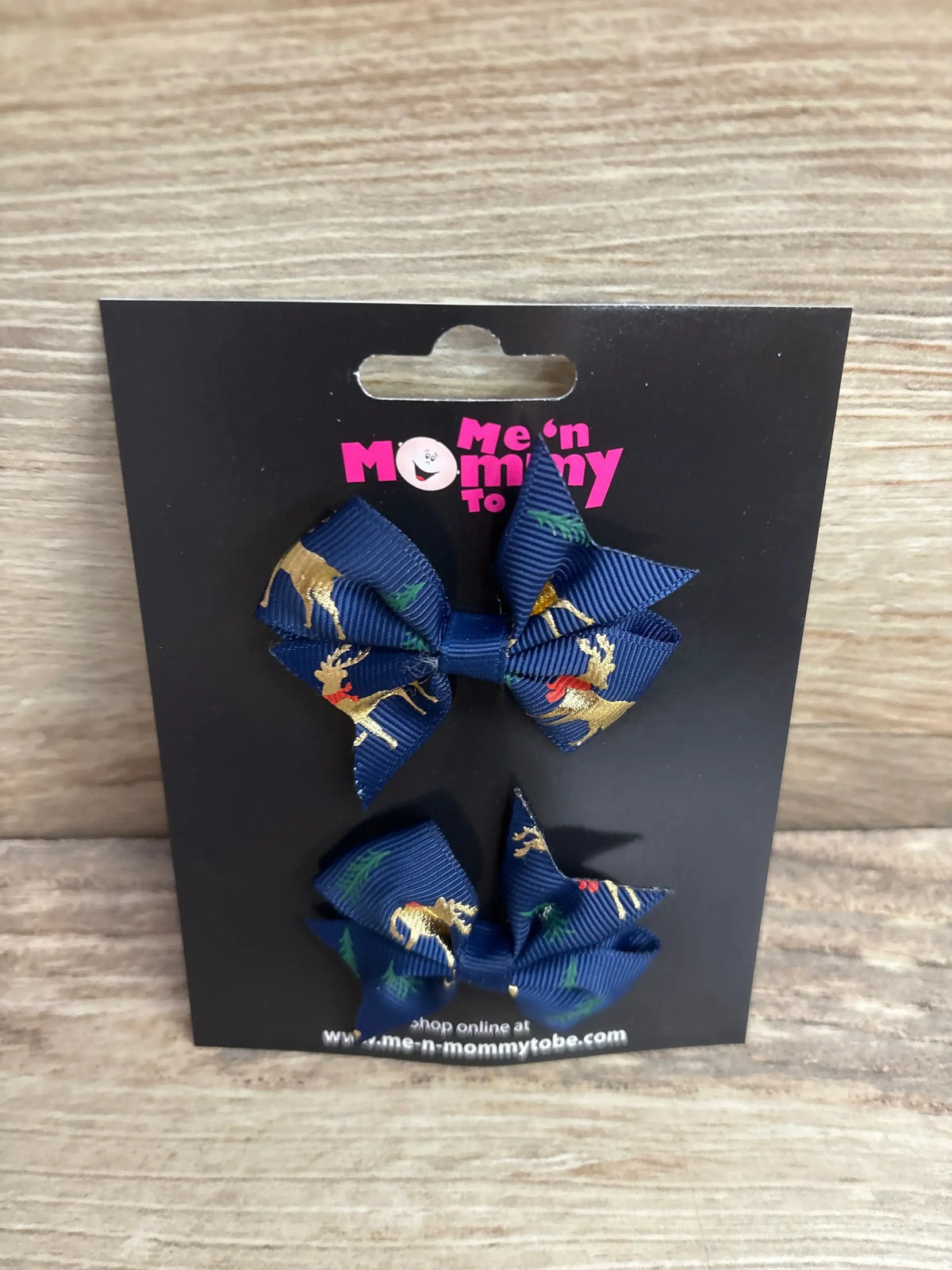 Navy blue holiday hair bows with gold reindeer and green trees, perfect for kids' festive outfits.