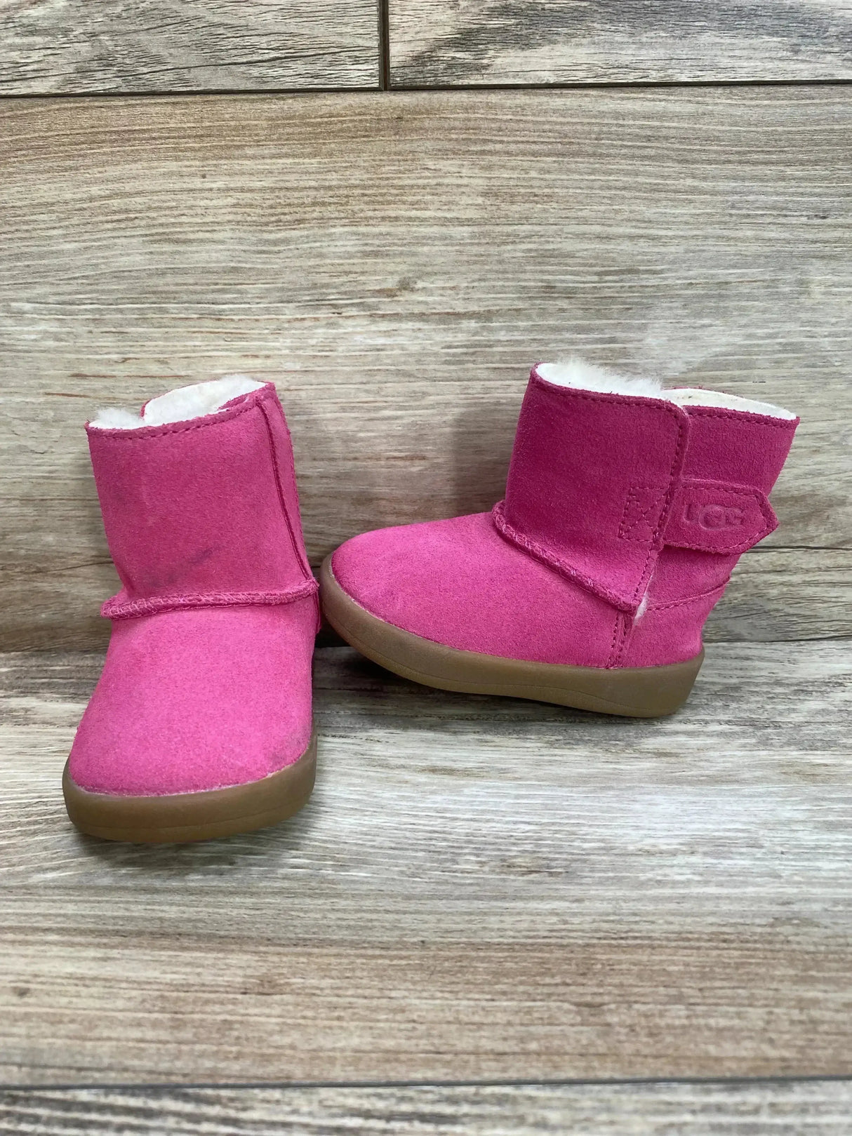 Side view of UGG Keelan boot in pink showcasing suede upper and plush sheepskin lining on white background