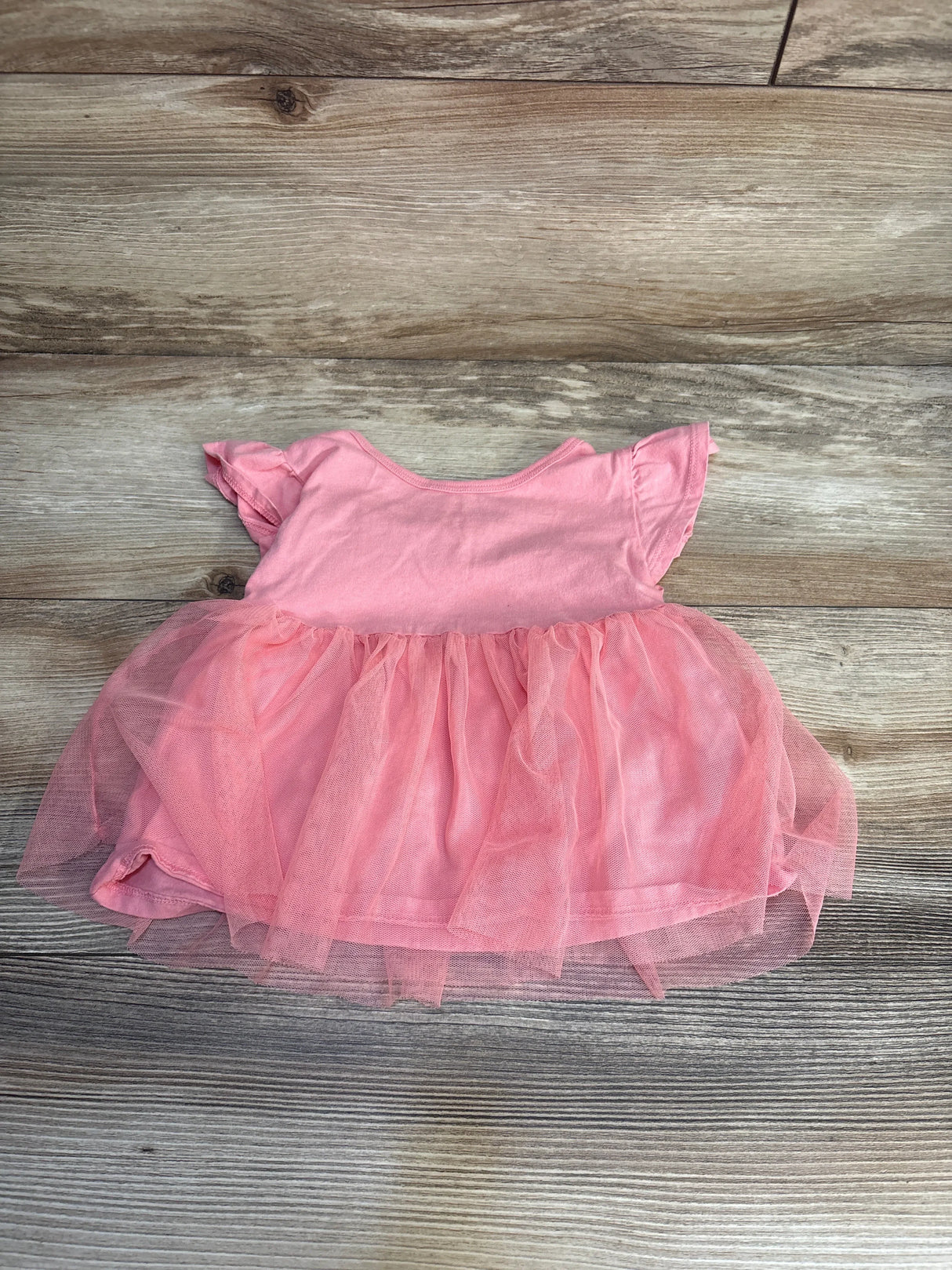 Pink baby girl dress with tulle skirt on wooden background, gently used kids clothing