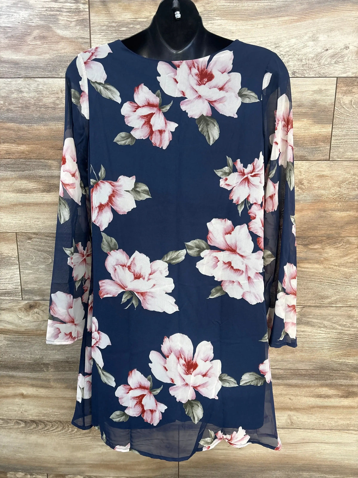 Front view of floral V-neck maternity dress in navy showing large pink-and-white flowers and sheer long sleeves on mannequin