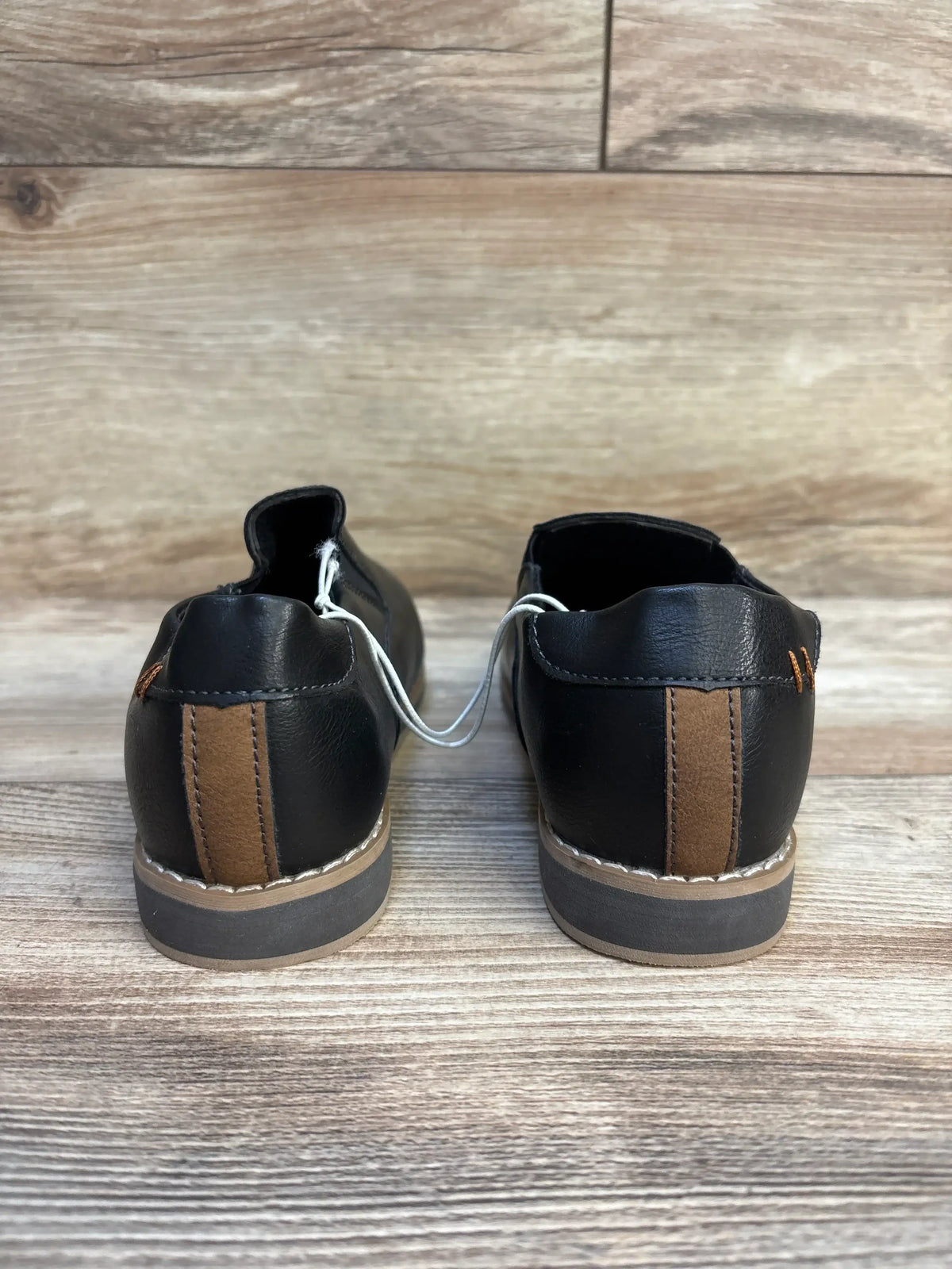 Back view of Cat & Jack Neal black toddler loafers showing brown heel tab and tan stitched sole on wood background